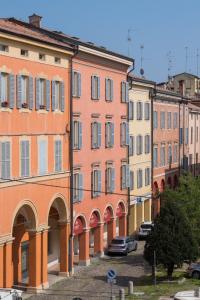 a row of colorful buildings in a city at Hotel Rua Frati 48 in San Francesco in Modena