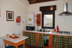 uma cozinha com um lavatório e uma bancada em Etna Casa Llera-Antica casa siciliana em Milo
