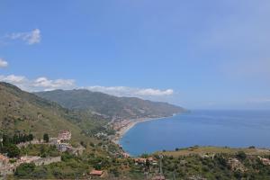 uitzicht op een stad op een heuvel naast de oceaan bij Hotel "La Pensione Svizzera" in Taormina