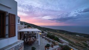 a building with a table and chairs and a sunset at Loukia Apartments in Artemonas