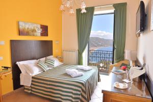 Habitación de hotel con cama y ventana grande en Hotel "La Pensione Svizzera", en Taormina