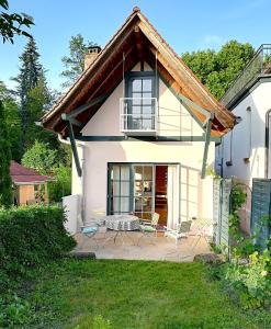 ein weißes Haus mit Stühlen und einer Terrasse in der Unterkunft Atelierhaus Beckmann in Gengenbach