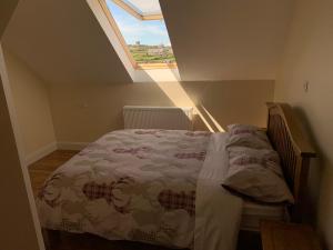 a bedroom with a bed in a attic with a window at Cliffs of Moher View in Inisheer