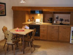 a kitchen with a wooden table and a table and chairs at Pension Loni Theisen in Kelberg
