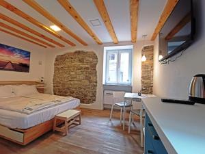 een slaapkamer met een bed in een kamer met een stenen muur bij Ribiška hiša - Old Piran Fisherman's House in Piran +44 foto's