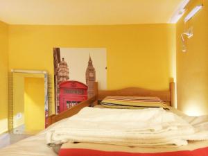 Habitación amarilla con cama y foto de Big Ben en Europa Hostel Portorož, en Portorož