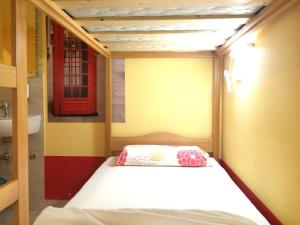 a small bedroom with a bed and a red door at Europa Hostel Portorož in Portorož