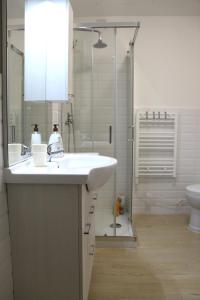 y baño blanco con lavabo y ducha. en Along the Canal smart flat Naviglio - 4 people en Corsico