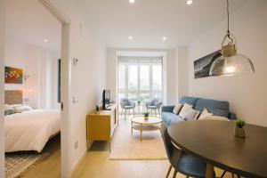 a living room with a blue couch and a table at PRIM 26 in Donostia-San Sebastián