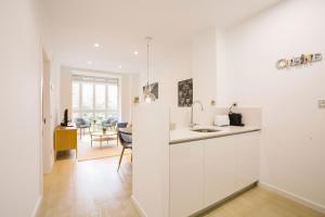 a kitchen with white cabinets and a dining room at PRIM 26 in Donostia-San Sebastián