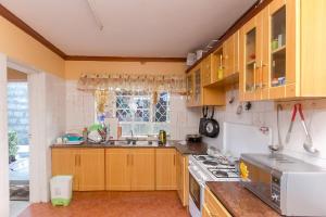 a kitchen with wooden cabinets and a sink and a window at Zarita Boutique Hotel in Nairobi