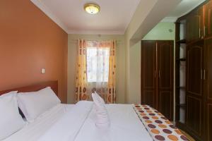 - une chambre avec un lit blanc et une fenêtre dans l'établissement Zarita Boutique Hotel, à Nairobi