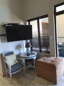 een woonkamer met een stoel en een televisie bij Cabana Del Mar 69 in Amanzimtoti