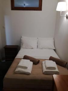 una camera da letto con un letto con due asciugamani sopra di House in the forest a Tsagarada
