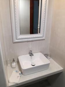 un bagno con un lavandino bianco e uno specchio di House in the forest a Tsagarada