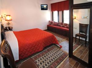 
a bed room with a red bedspread and a red dresser at Guesthouse Konstantinos Bakaris in Kastoria
