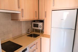 a kitchen with a white refrigerator and a microwave at Apartamento en el centro de Sevilla in Seville