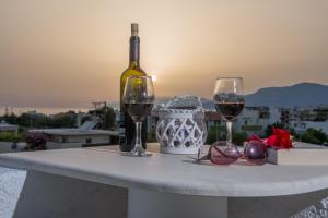 カラマキにあるHoumeli Maisonettes & Apartmentsのワイン1本とグラス2杯付きのテーブル