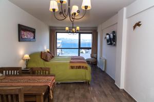 une chambre avec un lit, une table et une fenêtre dans l'établissement Studio Bariloche, à San Carlos de Bariloche