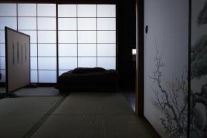 Habitación con cama frente a una ventana en Hostel Tomal, en Kagoshima