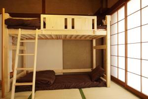 two bunk beds in a room with windows at Hostel Tomal in Kagoshima