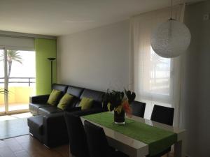 a living room with a couch and a table at Apartamento Primera Linea de Mar, Cunit in Cunit