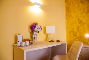 Pokój z biurkiem z wazą kwiatów i lampą w obiekcie Affittacamere Rosy w mieście La Spezia +29 zdjęć