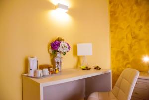 una camera con scrivania, vaso di fiori e lampada di Affittacamere Rosy a La Spezia