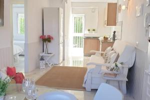 een woonkamer met een witte bank en een keuken bij Los Geranios - Beach Apartment in La Cala de Mijas