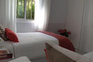 een slaapkamer met 2 bedden met rode kussens en een raam bij Los Geranios - Beach Apartment in La Cala de Mijas +14 foto's