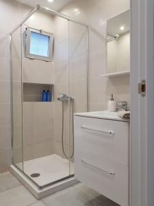 een witte badkamer met douche en wastafel bij Los Geranios - Beach Apartment in La Cala de Mijas