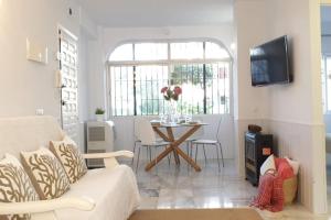 een woonkamer met een bank en een tafel bij Los Geranios - Beach Apartment in La Cala de Mijas