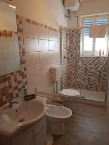 a bathroom with a sink and a toilet and a shower at Case La Spiaggia in Sciacca
