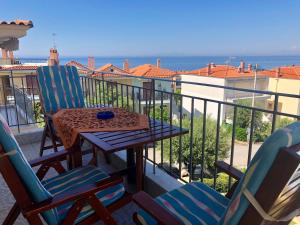 balcón con mesa, sillas y vistas al océano en Gerakini 2BR Apt with Shared Pool, en Gerakini
