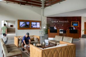 a man sitting on a table in a lobby at Casa Andina Select Pucallpa in Pucallpa