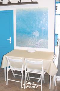 ファヴィニャーナにあるCasa Leonardoの絵画のある部屋のテーブルと椅子
