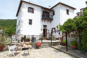 a white house with a patio and a table at Archontiko Panagoula in Portaria