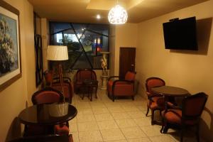 una sala de espera con mesas, sillas y TV en Hotel Santa Maria, en Lima