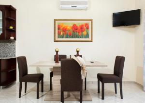 uma mesa de jantar com cadeiras e um quadro de tulipas em Mavros Molos Seaside Apartment em Kissamos