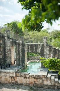 um antigo edifício de pedra com uma piscina em Coqui Coqui Papholchac Coba Residence & Spa em Cobá