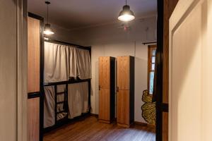 a room with a hallway with wooden floors and a door at Che Juan Hostel BA in Buenos Aires