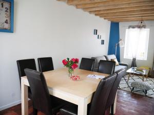 una mesa de comedor con sillas y un jarrón de flores. en Casa Maya en Saint-Aignan
