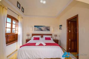 sypialnia z dużym łóżkiem z czerwonymi i białymi prześcieradłami w obiekcie Villa Valentina - LH156 By Villas Now Ltd w mieście Playa Blanca