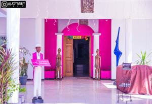 a man standing at a podium in front of a pink building at La maison de celine in Dakar