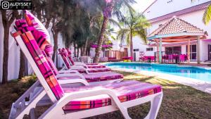 a row of lounge chairs next to a swimming pool at La maison de celine in Dakar