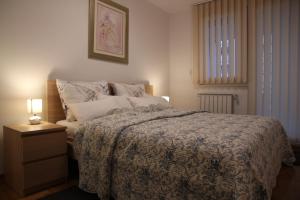 ein Schlafzimmer mit einem Bett und einer Lampe auf einem Nachttisch in der Unterkunft Vana apartment Zagreb in Zagreb