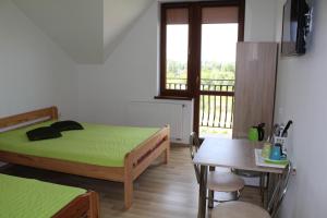 a bedroom with two beds and a table and a window at Albatros in Gąski