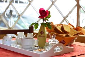 een tafel met een dienblad met een roos in een vaas bij El Balcon Hostal Turistico in Arequipa