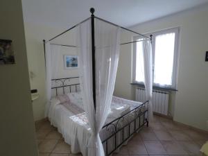 1 dormitorio con cama con dosel y ventana en B&B Oasi Verde en Corvara