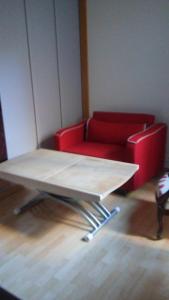 una mesa y un sofá rojo en una habitación en Studio climatisé Corps Saints, en Aviñón